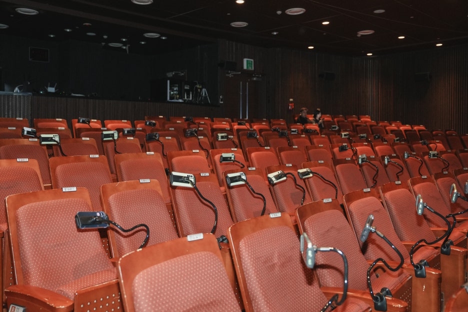 객석 좌석마다 거치대로 설치된 유니스텝 자막 단말기(휴대폰)