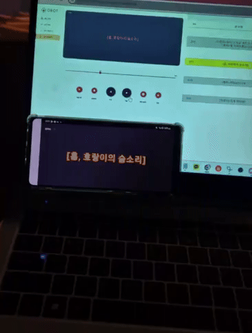 [이미지(GIF): 노트북 송출 화면과 그 앞 휴대폰에 효과음 자막 "[흠, 호랑이의 숨소리]" 동시 표시 (화면 작은 글씨 [판독 불가])