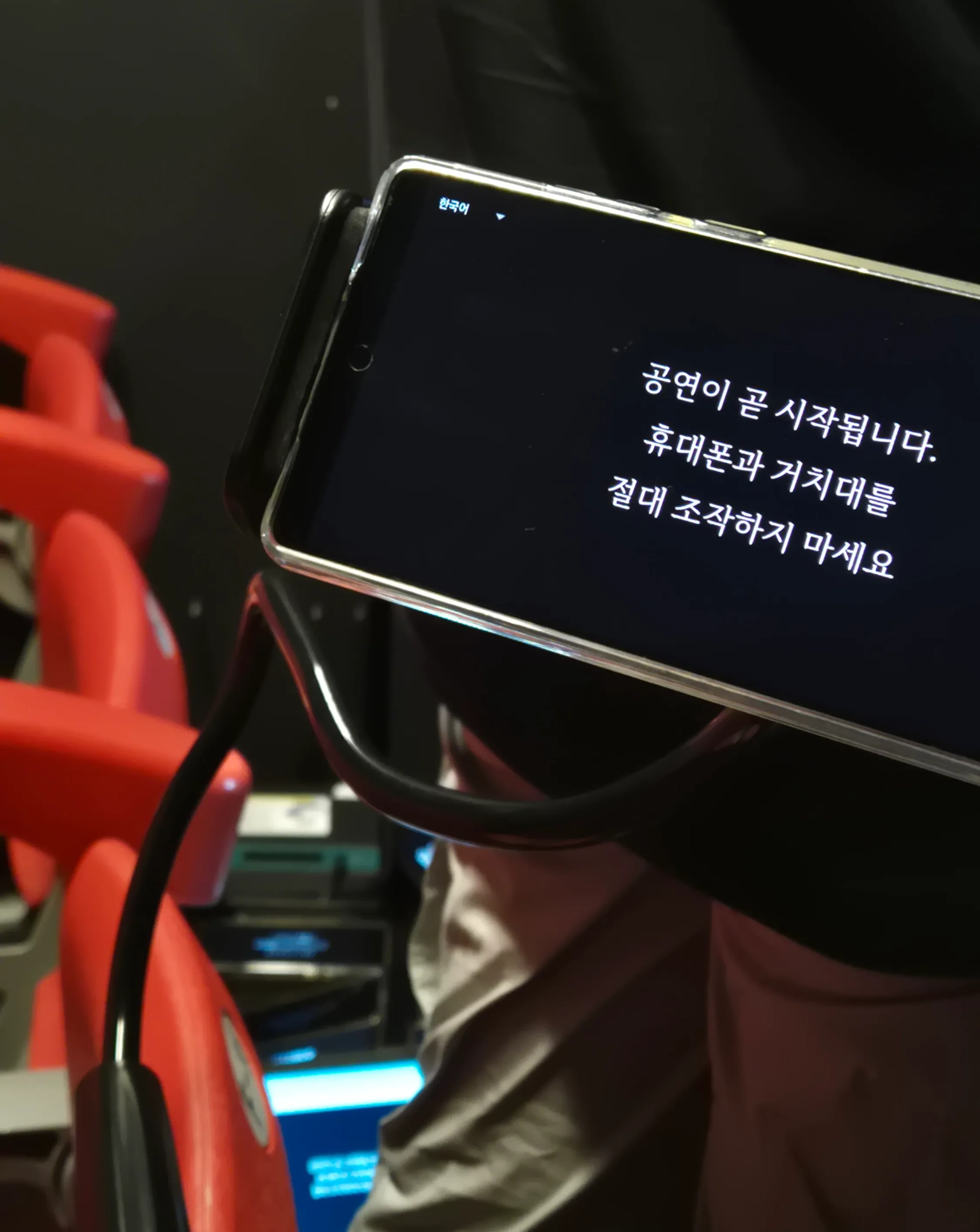 좌석 거치대 휴대폰 안내 자막 "한국어 / 공연이 곧 시작됩니다. 휴대폰과 거치대를 절대 조작하지 마세요"