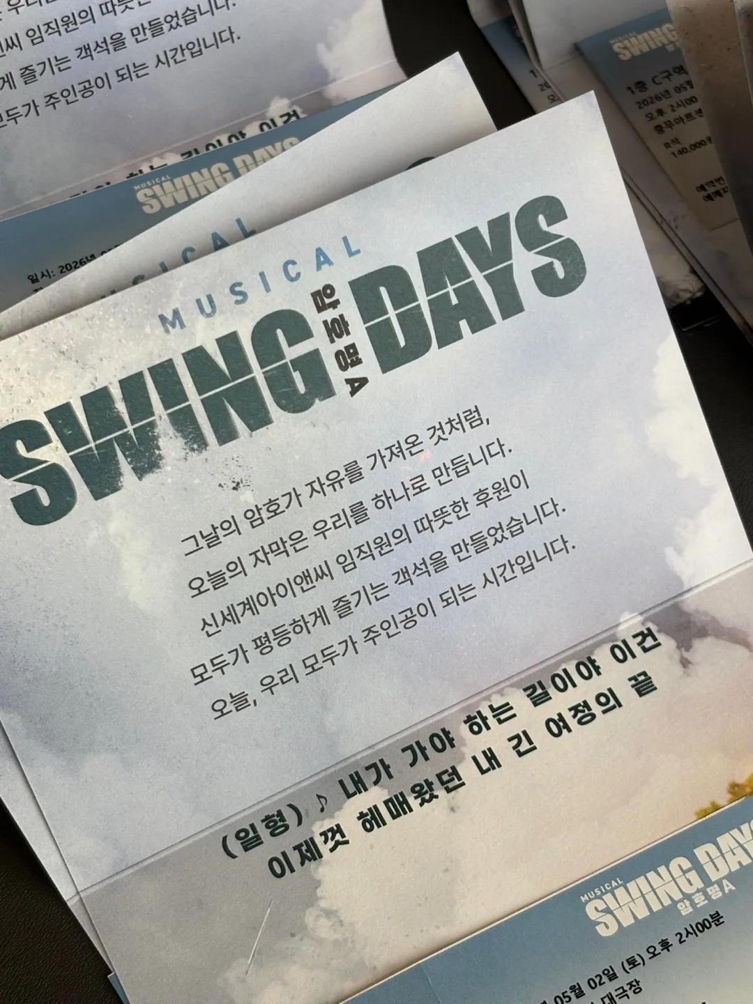 안내 리플릿 — "그날의 암호가 자유를 가져온 것처럼, / 오늘의 자막은 우리를 하나로 만듭니다. / 신세계아이앤씨 임직원의 따뜻한 후원이 / 모두가 평등하게 즐기는 객석을 만들었습니다. / 오늘, 우리 모두가 주인공이 되는 시간입니다." 아래에 극중